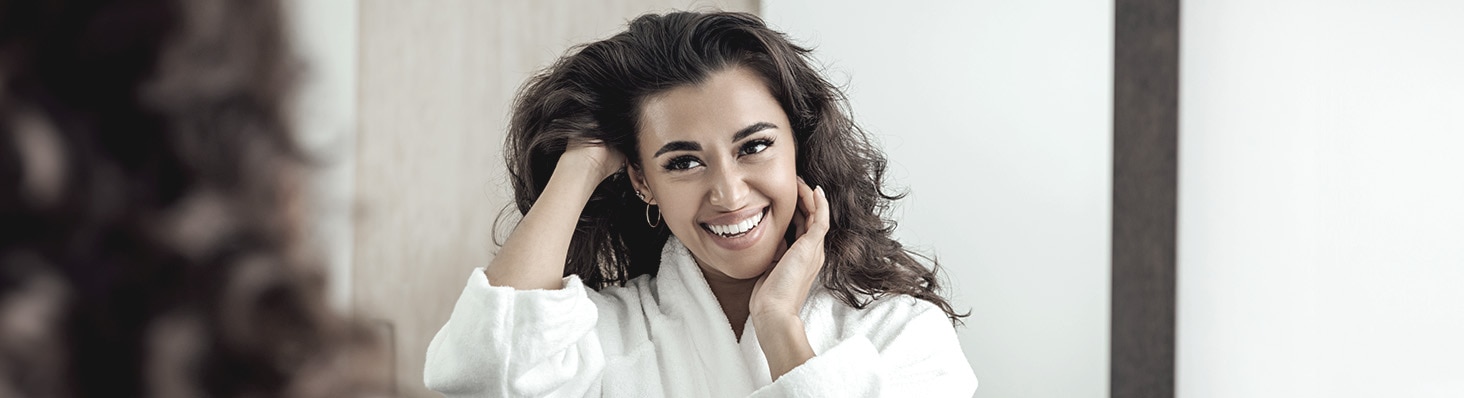 Mujer frente al espejo mirando su cabello